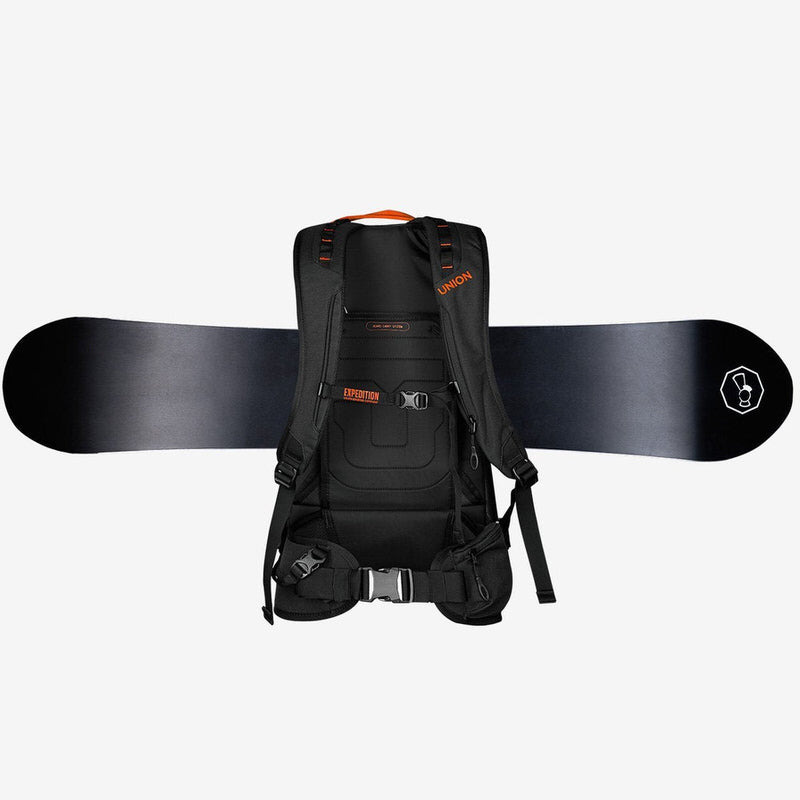 Schwarzer Rucksack mit Snowboard Schwarzer Union Expedition Rucksack mit orangefarbenen Akzenten und Snowboard auf weißem Hintergrund.
