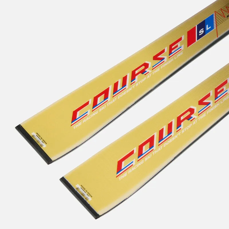 Detailed view of two gold-colored skis with the inscription "COURSE" in red and blue, labeled "The Racing Ski That Doesn't Stop At The Finish Line".