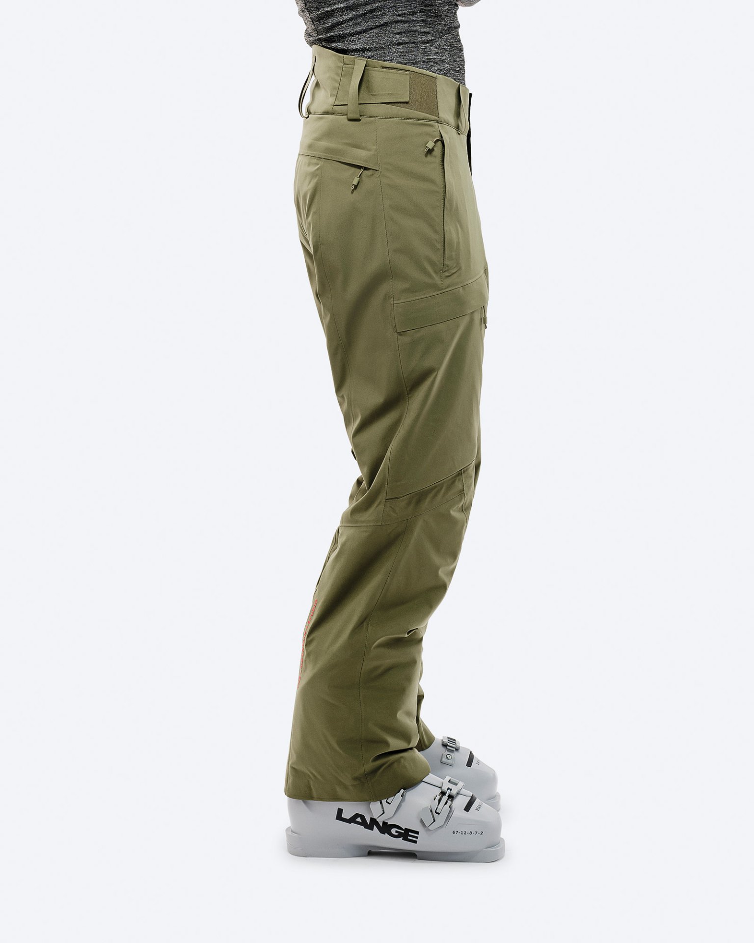 Winter Moss GORE-TEX Hose Person trägt Winter Moss GORE-TEX 2L Stretch Insulated Pants über Skischuhen vor weißem Hintergrund.