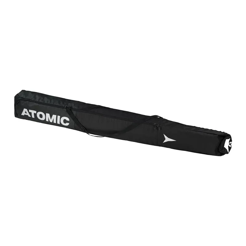 Sac à skis Atomic Single noir, couché sur le côté, avec sangle de transport et logos.