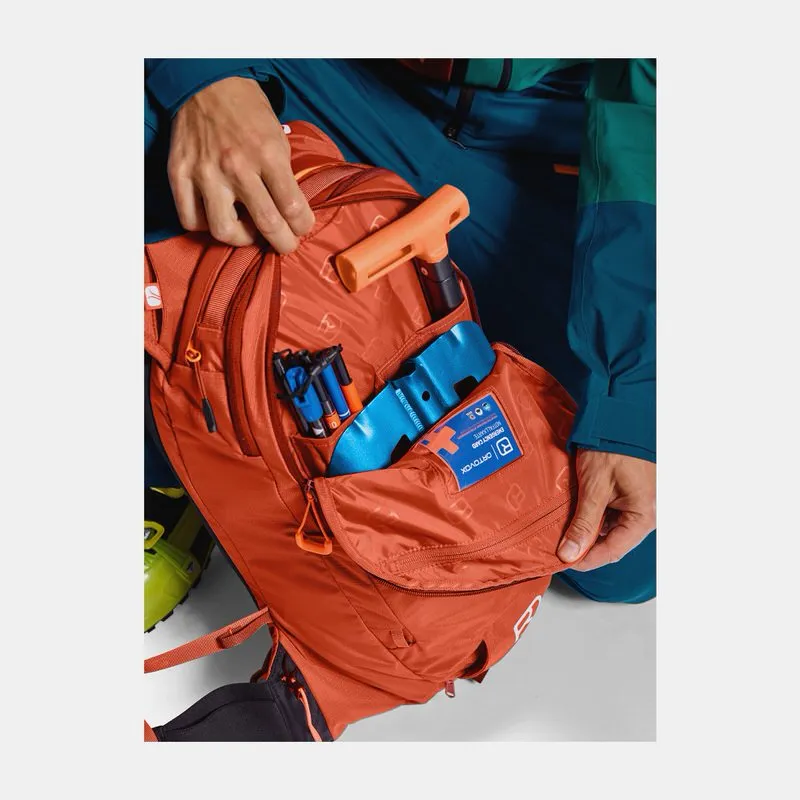 Primo piano: zaino Freerider 22 blu petrolio, aperto, con attrezzatura da valanga.