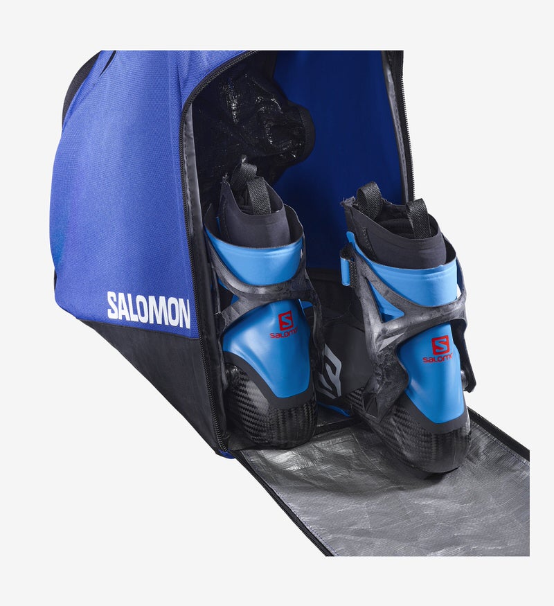 Sac à chaussures de ski bleu ouvert Salomon avec chaussures de ski à l'intérieur, intérieur argenté.