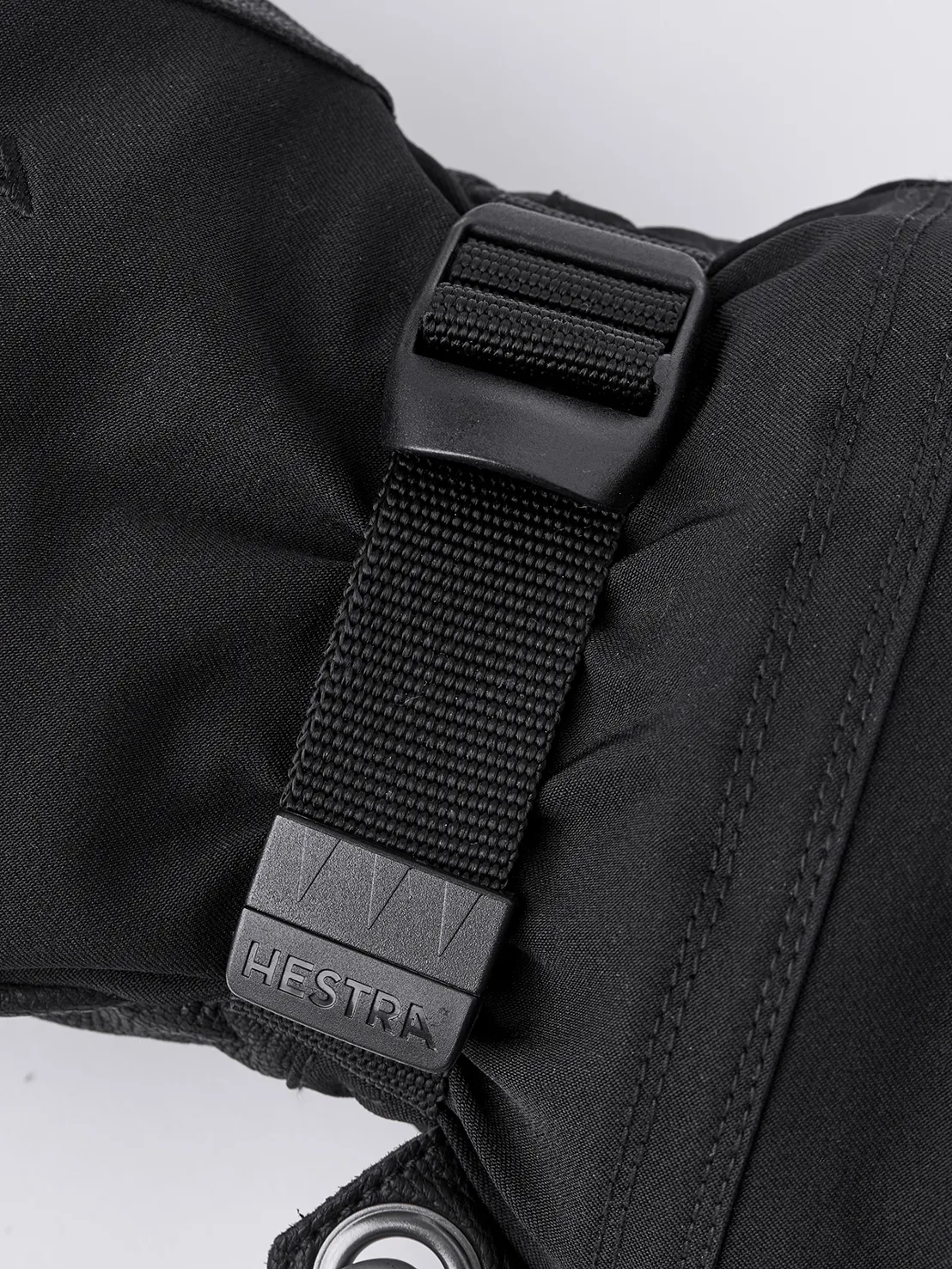 Vue détaillée d'une Hestra Army Leather Extreme Mitt noire avec fermeture et logo.