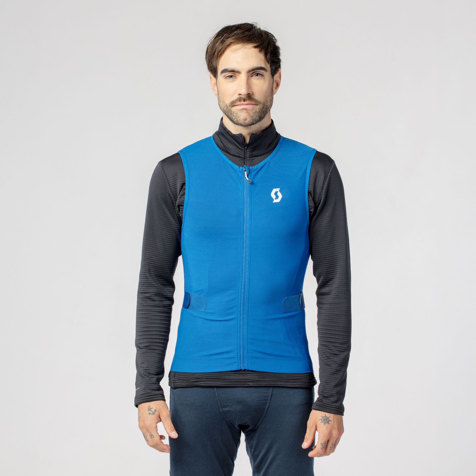 Mann trägt blaue Scott Airflow Herren Protektor-Weste mit Reißverschluss und Logo, dazu schwarzes Oberteil.