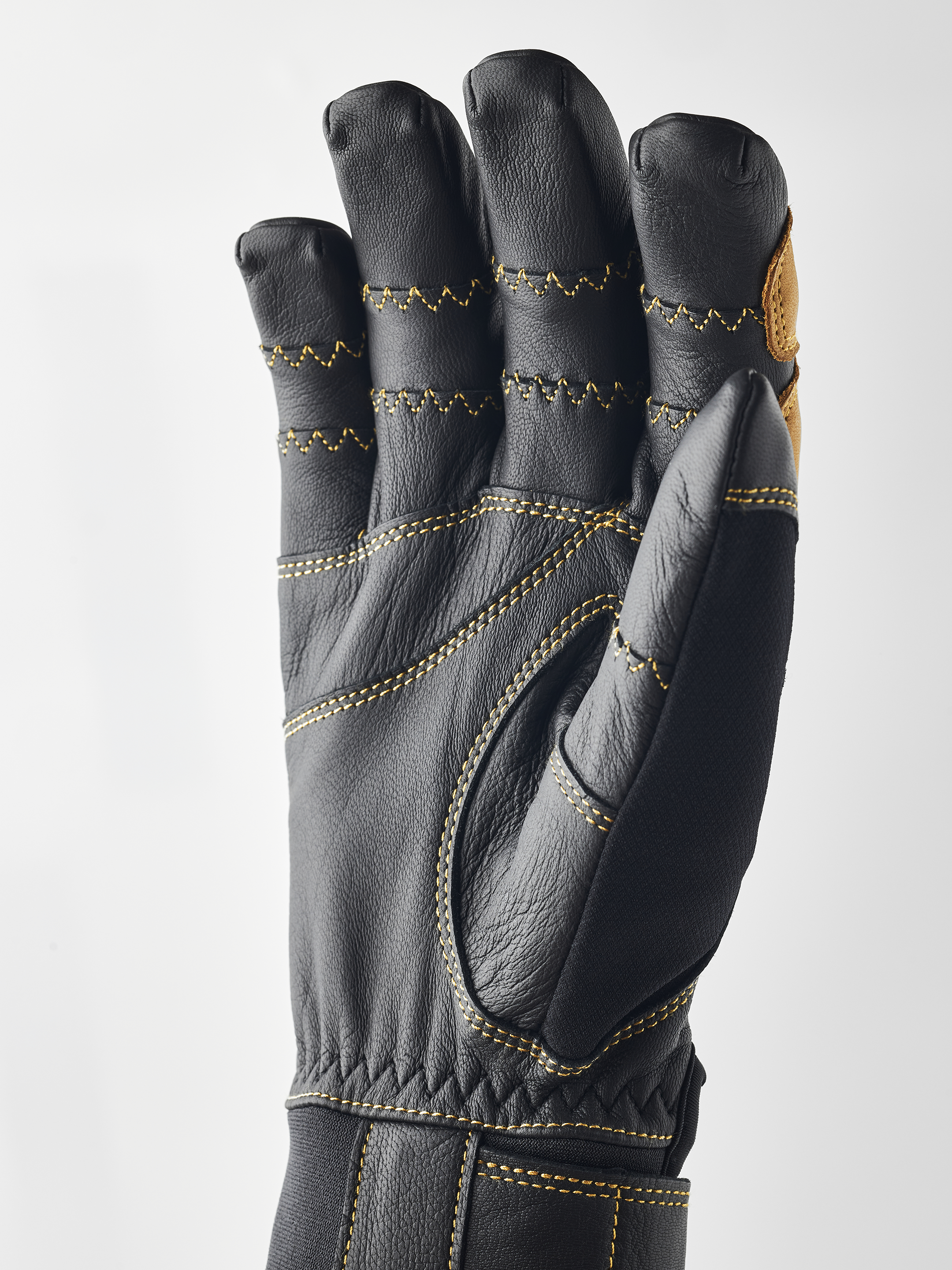 Gant noir Hestra Ergo Grip Active, paume vers l'avant, coutures jaunes.