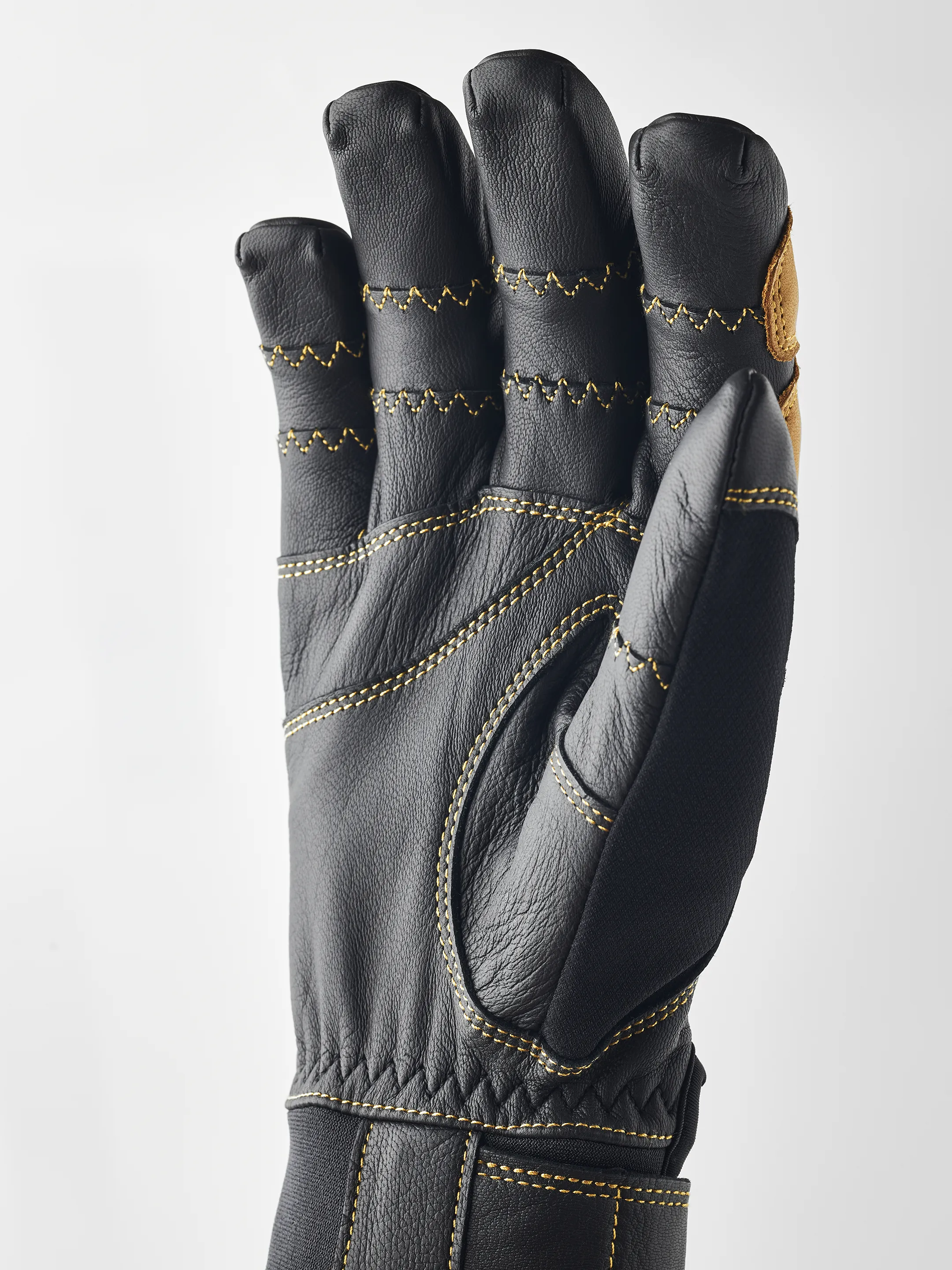 Schwarzer Hestra Ergo Grip Active Handschuh, Handfläche nach vorn, gelbe Nähte.