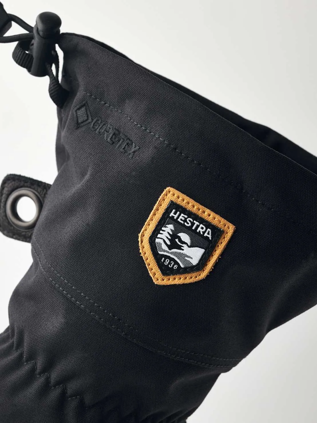 Detailed view of a black Hestra glove with Gore-Tex and a Hestra logo patch with the lettering "1936".
