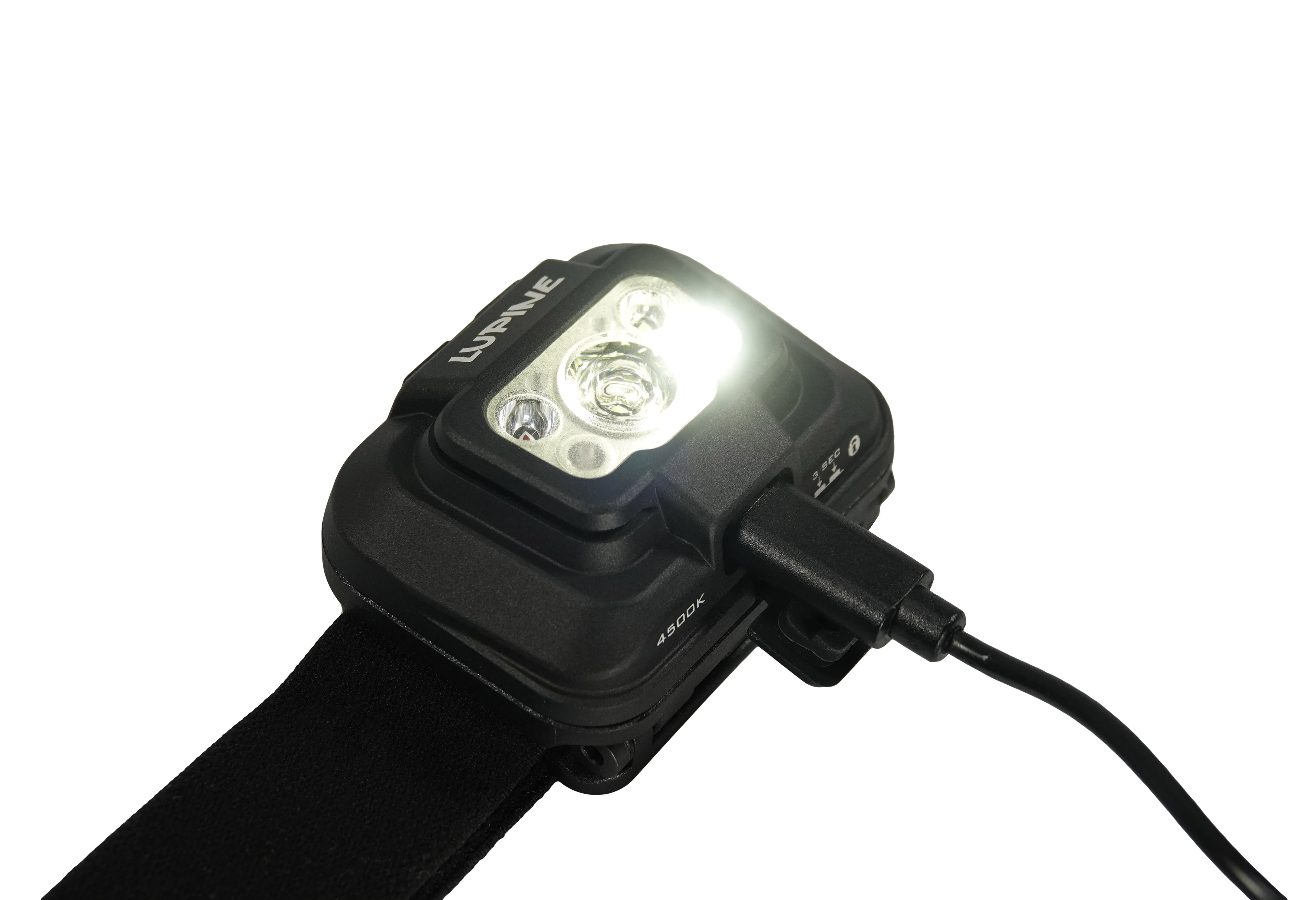 Schwarze Penta 4500k Stirnlampe, am Ladekabel, mit eingeschaltetem, hellem Licht.
