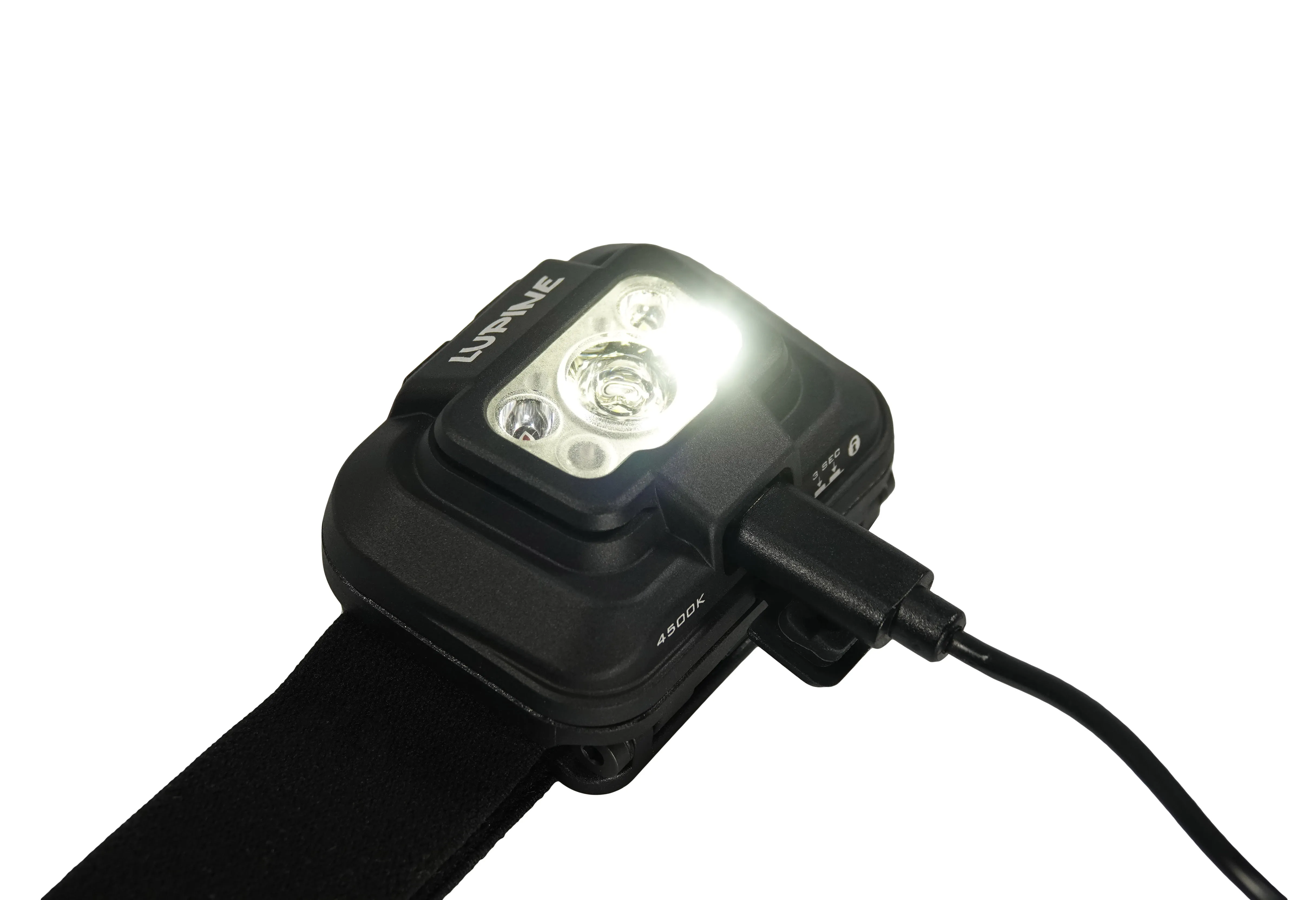 Lampe frontale Penta 4500k noire, sur le câble de recharge, avec lumière vive allumée.