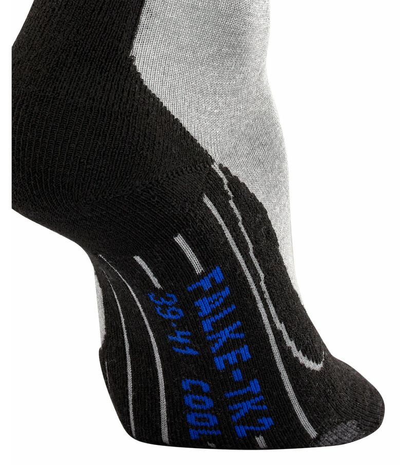 Détail d'une chaussette de trekking Light Grey TK2 Cool. Noir au talon, gris clair au dos du pied avec le logo de la marque en bleu.
