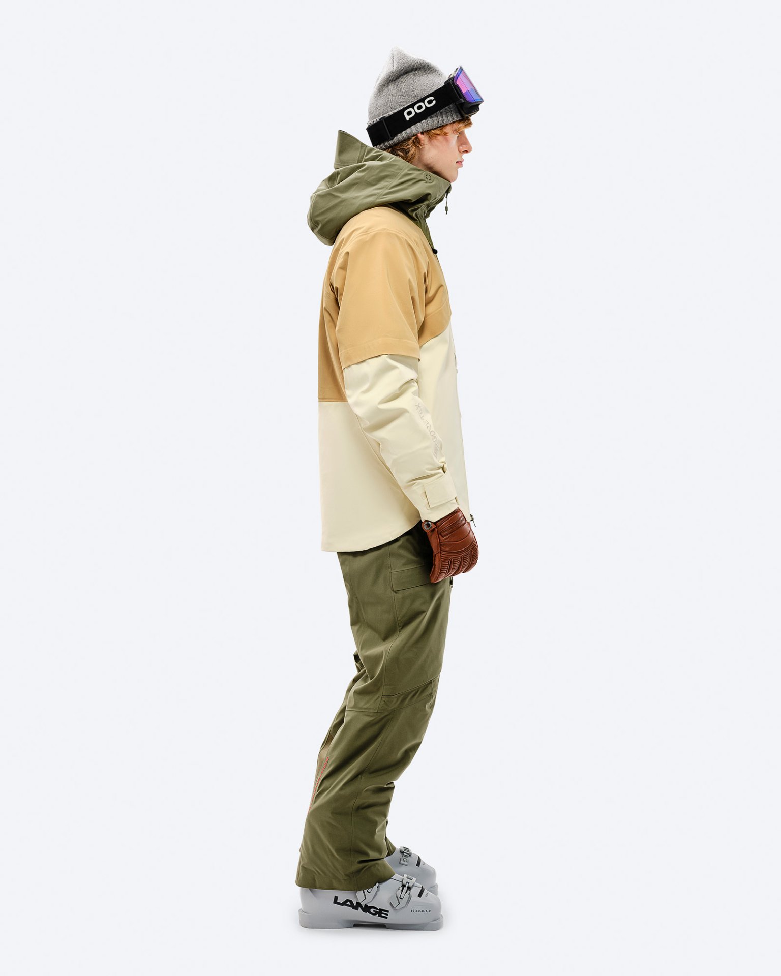 Winterkleidung in Moss Person mit Winterkleidung in Winter Moss Farbe, mit Gore-Tex 2L Stretch Insulated Hose und Skischuhen im Profil.