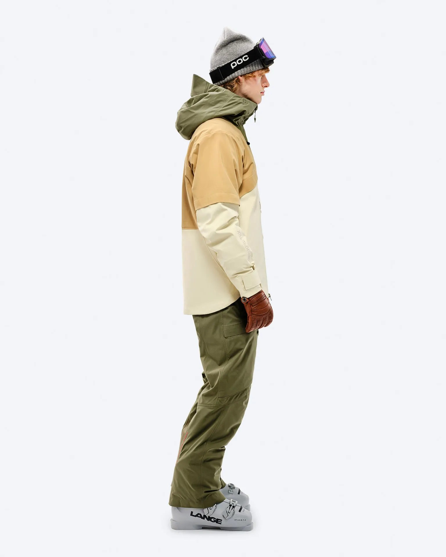 Person with winter clothing in Winter Moss color, with Gore-Tex 2L Stretch Insulated pants and ski boots in profile.