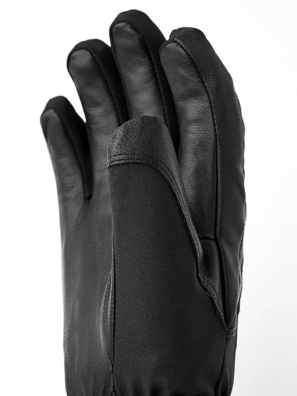 Gros plan sur un gant en cuir noir, la paume tournée vers le haut et les doigts légèrement écartés.