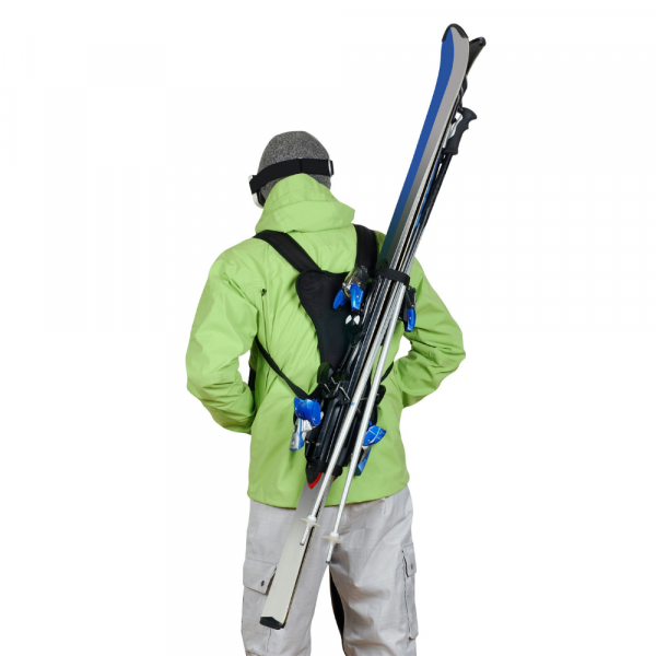 Person von hinten mit Skiback: Skier und Stöcke sind auf dem Rücken wie mit einem Rucksack befestigt.