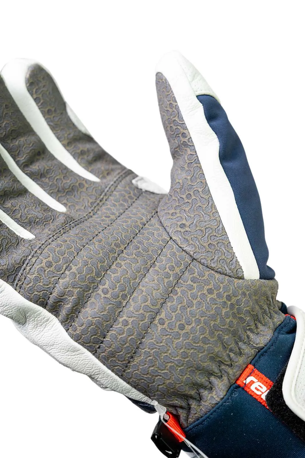 Close-up of a glove with a gray palm, white stripes on the fingers and navy blue fabric.