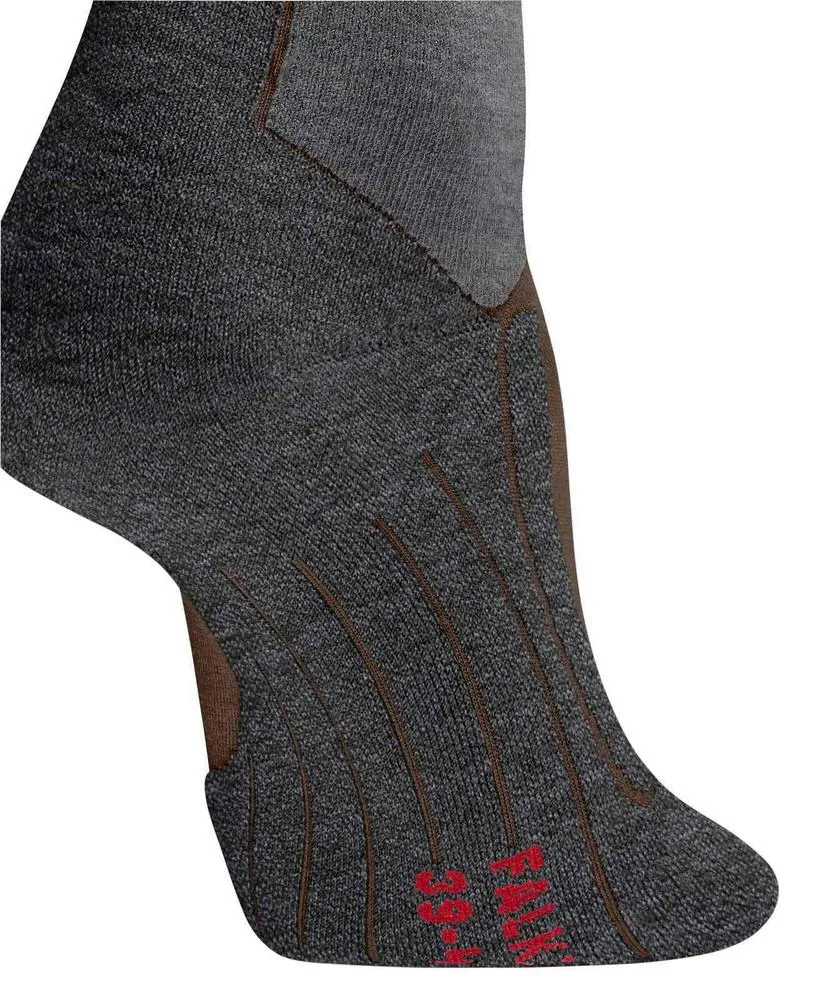 Zoom sur la zone du pied et de la cheville d’une chaussette gris foncé avec parties claires. Des lignes décoratives verticales marron vont du milieu du pied aux orteils. En bas du pied, inscription rouge en relief.