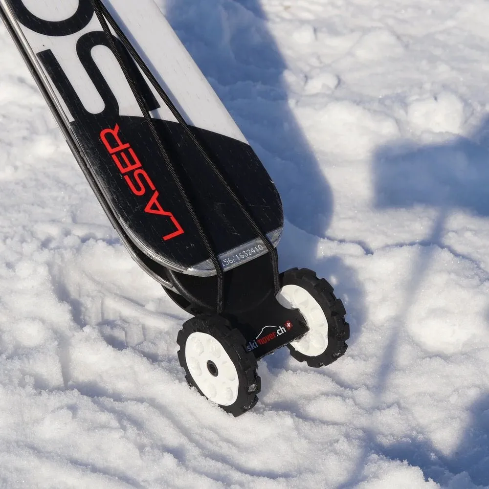 Skis with mounted Skimover Easy wheels in the snow, close-up.