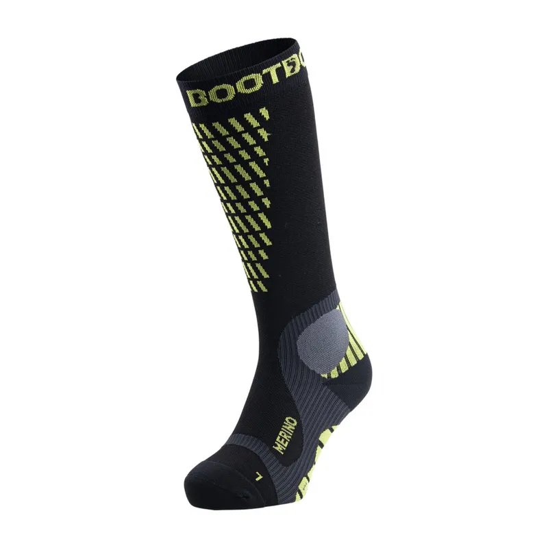 A black, knee-length compression sock from the brand BOOTDOC with yellow accents and Merino lettering.