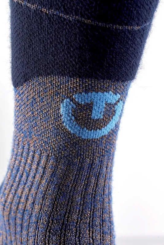 Close-up of a Therm-ic Ski Merino Reflector men's ski sock, with blue logo on blue-brown mottled background.