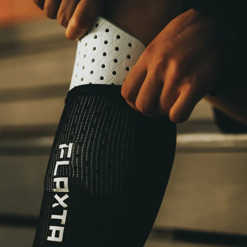 Close-up: Flaxta Aircon shin guards on the leg, ventilated design.