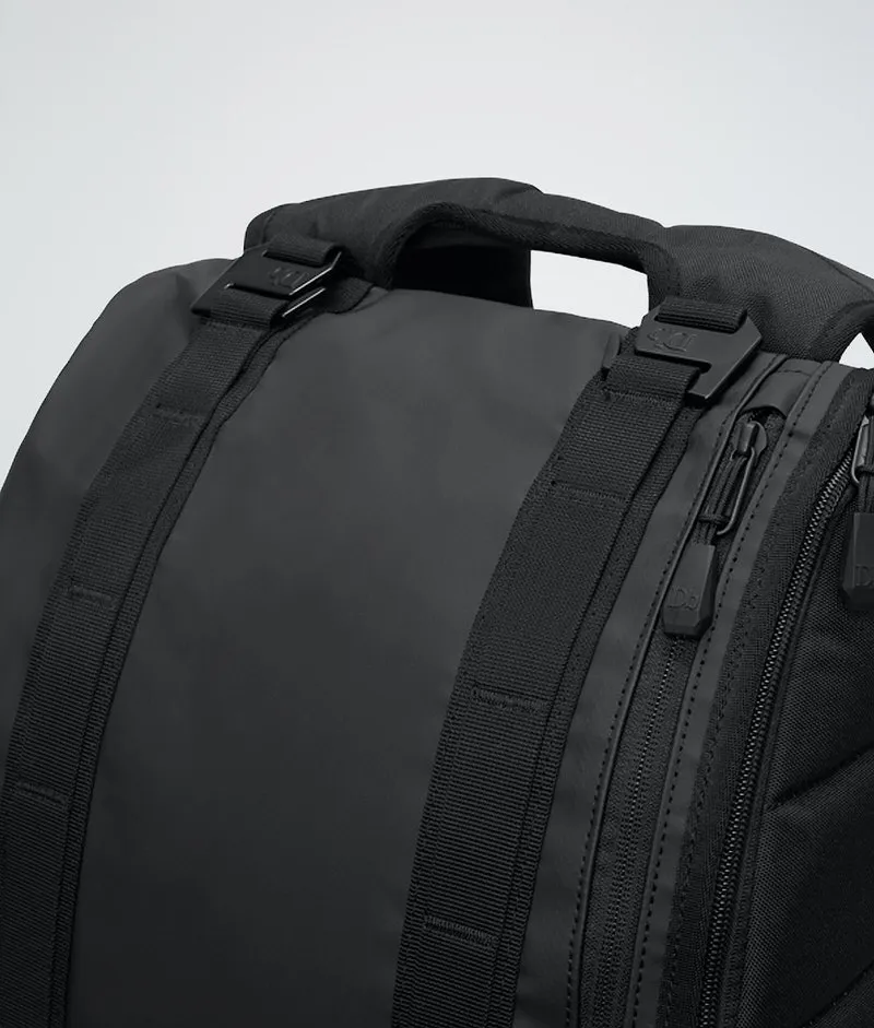 Detailansicht des Douchebags The Base 15L Rucksacks in Schwarz, mit Fokus auf Tragegriff, Gurte und Reißverschlüsse.