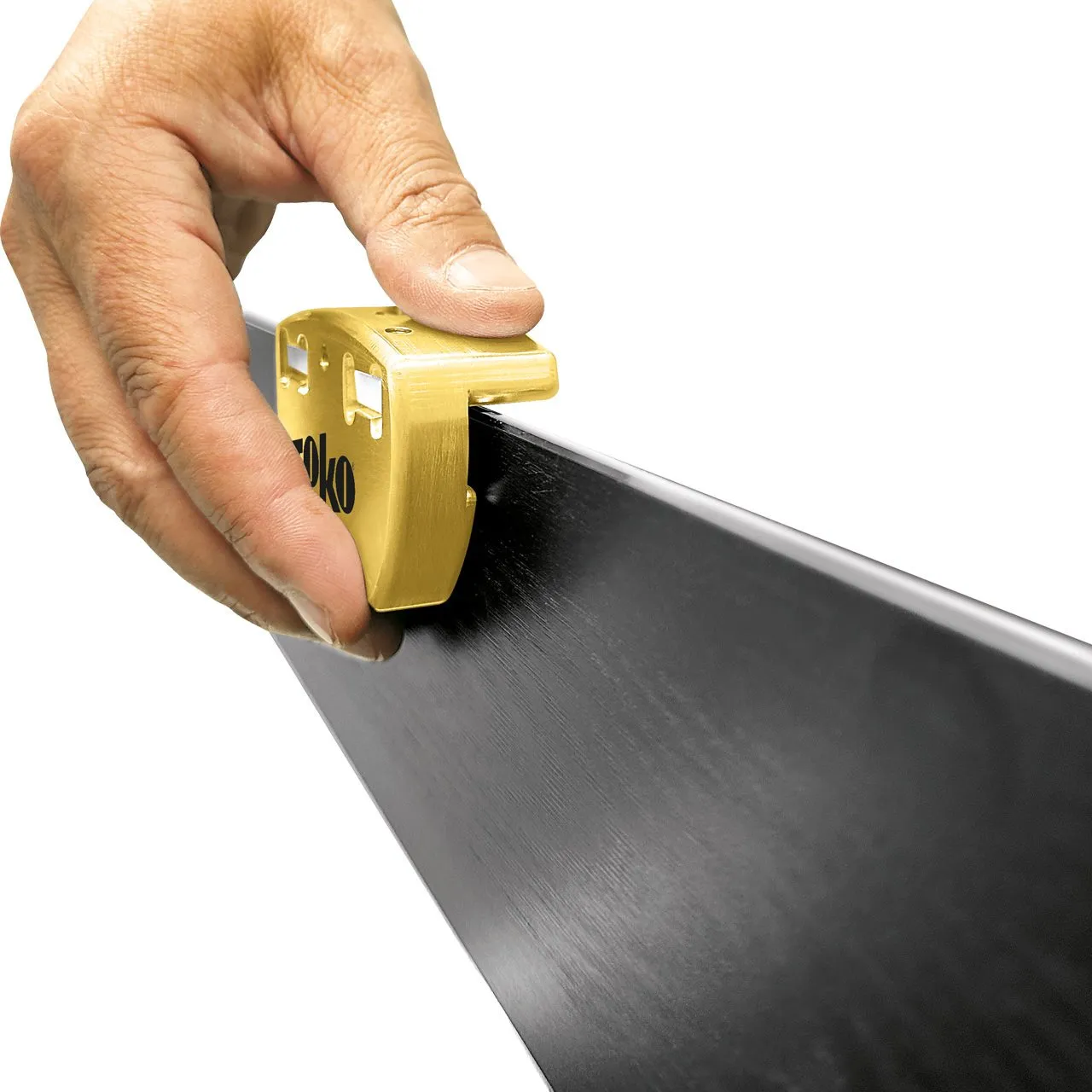 Hand guides golden Toko Ceramic Stone along the ski for precise edge finish.