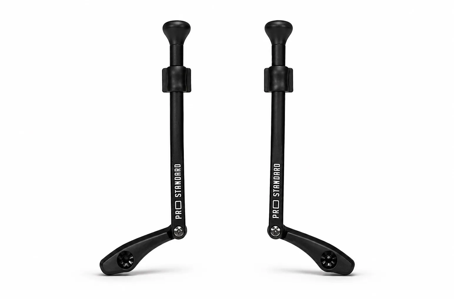 Two identical, slim, black support legs stand parallel on a white background. Each has a rounded cap at the top, a clamping mechanism below, and a base that curves outward at the bottom with a screw. "Pro Standard" in white.
