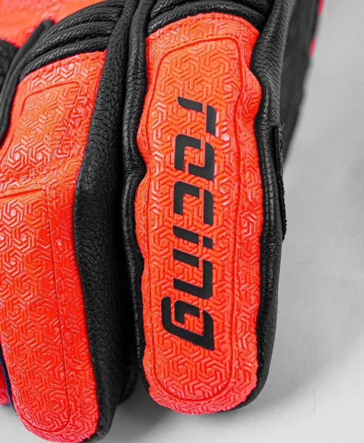 Close-up of a motorcycle glove; leather and orange material with pattern and lettering.