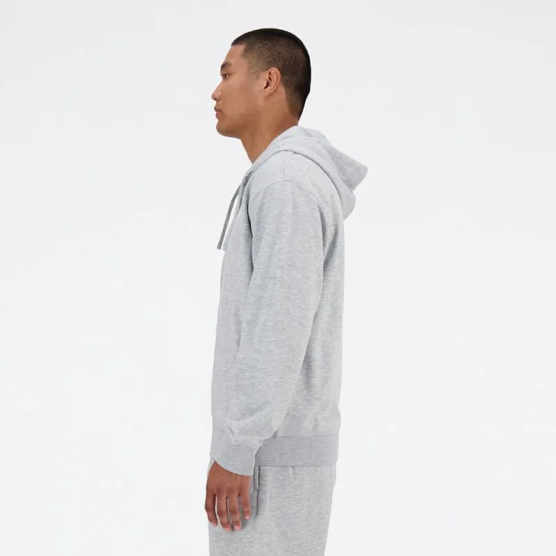 A man wearing a gray New Balance hoodie, side view.