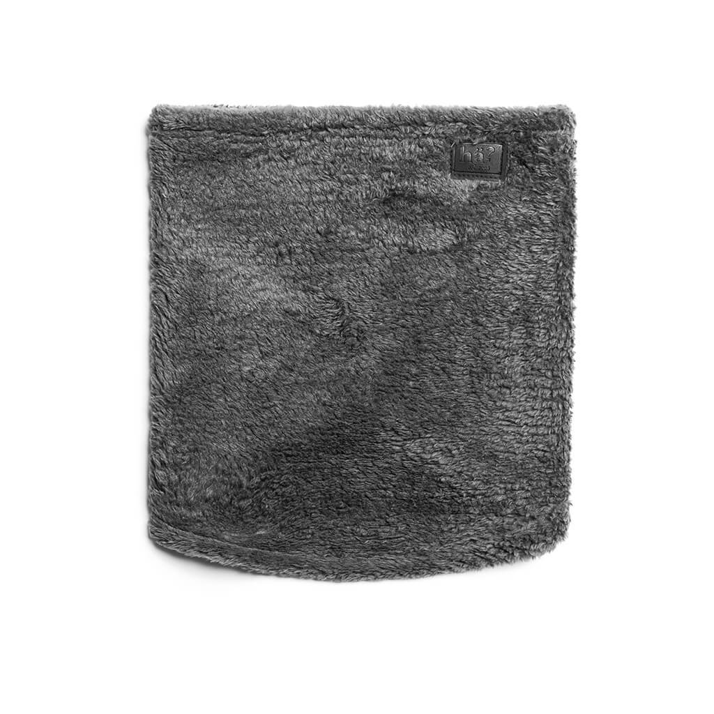 Grauer, flauschiger Wellness Neckwarmer mit kleinem, dunklem Lederpatch, isoliert auf weißem Hintergrund.