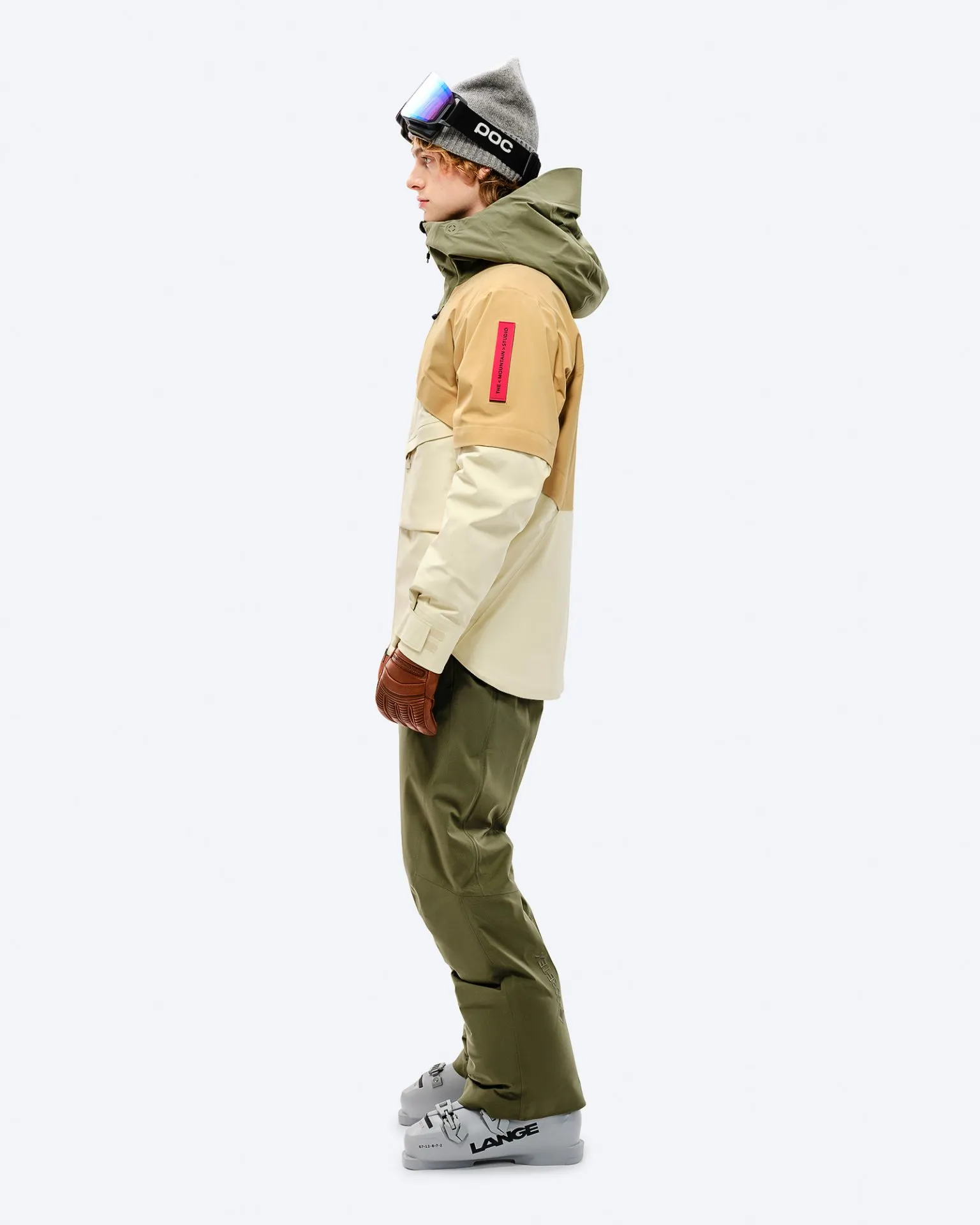 Man in winter gear, Winter Moss pants. Ski goggles, hat and ski boots complete the Look.