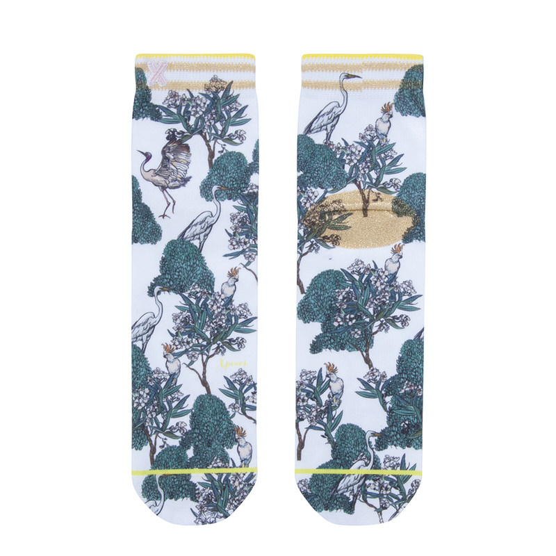XPOOOS Nica Socken, mit tropischem Vogelmuster, Bäumen und goldenen Akzenten auf weißem Grund.