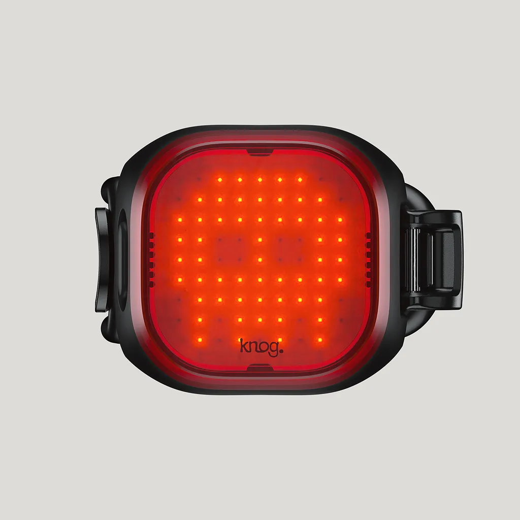 Gros plan sur un feu arrière noir Knog Blinder Mini Skull avec des LED rouges.