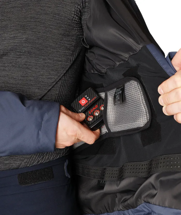Nahaufnahme: Person befestigt Lenz Heat Pads in Padded Jacket R2H 2.0. Detailaufnahme des Heizsystems in der Jacke.