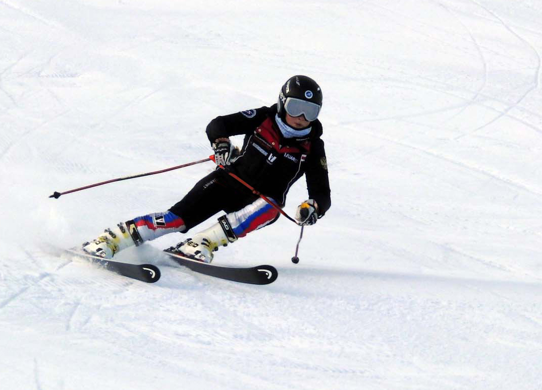 Skifahrer in Aktion auf Schnee, Ski Training, Fokus auf Körperposition und Skitechnik.