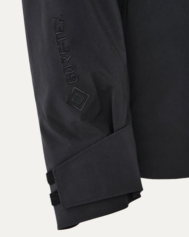 Detailansicht vom Ärmel der schwarzen Gore-Tex Jacke mit Logo und Klettverschluss.