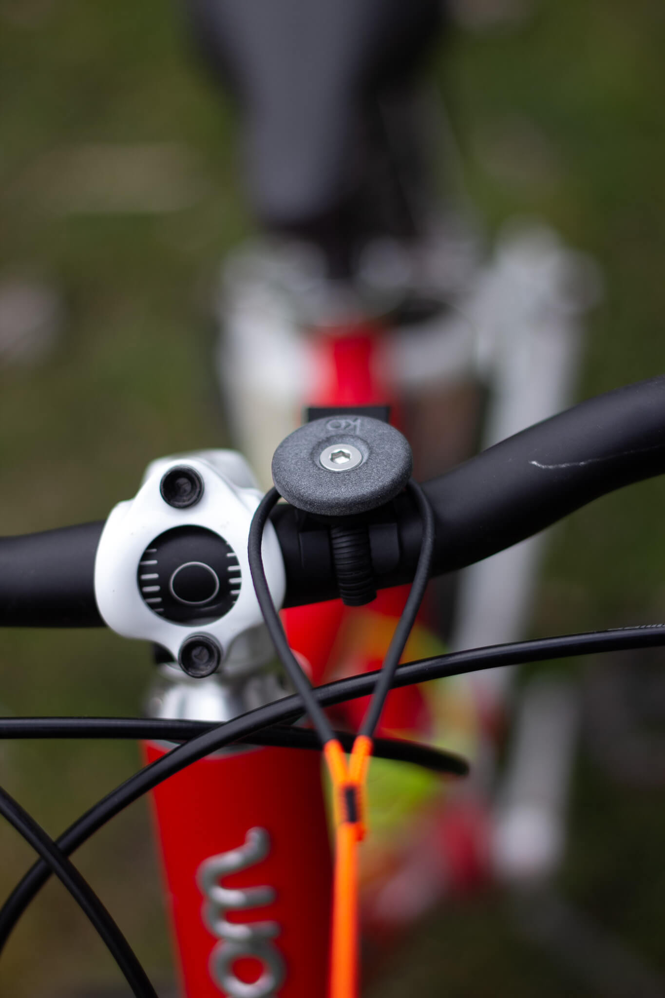 Nahaufnahme eines Fahrradlenkers mit montiertem Bike Mount Bundle und SP-Connect Micro Bike Mount. Zugschlaufe ist befestigt.