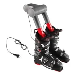Black ski boots with a gray dryer that is plugged into the boots and connected to a power cable.