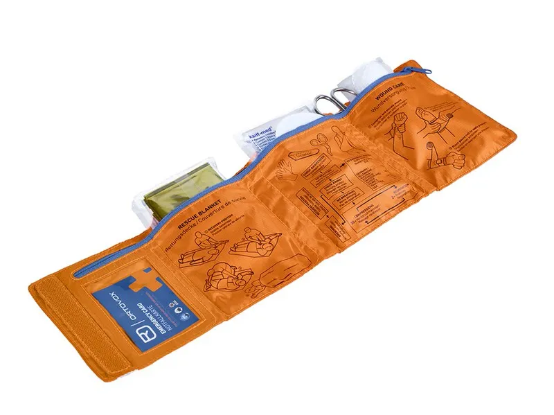 Offenes, orangefarbenes Ortovox First Aid Roll Doc Mid Set mit Rettungsdecke, Schere, Notfallkarte und Anleitungen.