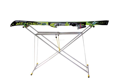Silberner Klapptisch mit Ski Silberner X-förmiger Klapp-Servicetisch mit Ski darauf, vor einem weißen Hintergrund.