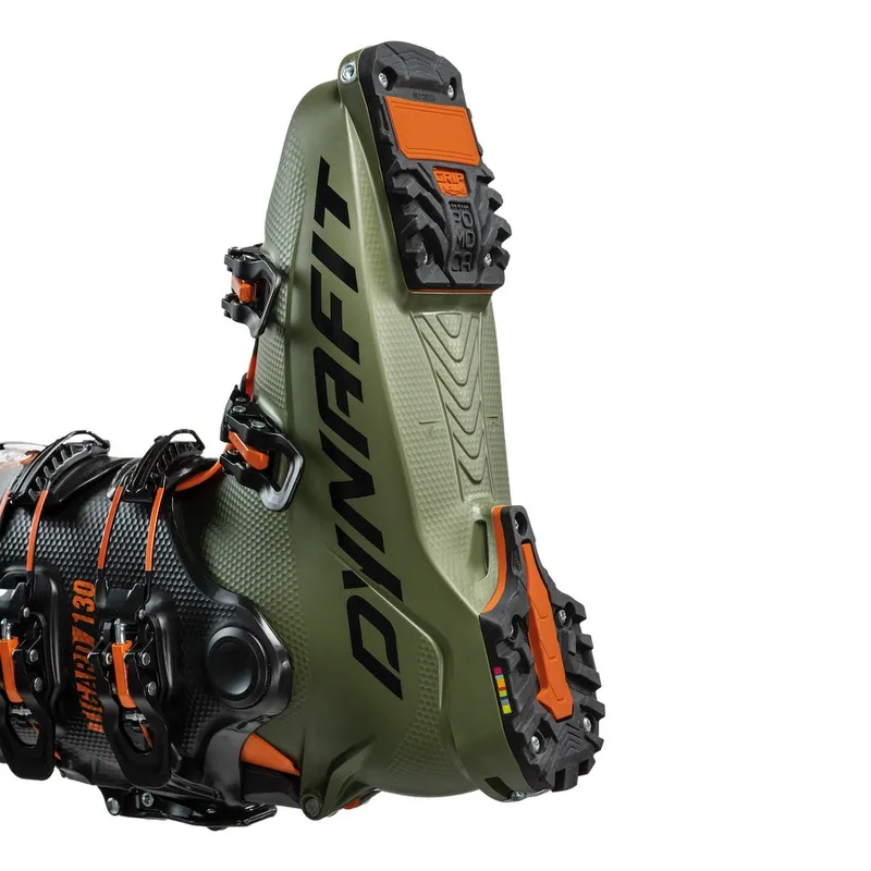 Gros plan sur une chaussure de ski de randonnée unisexe Dynafit Tigard Alpine Tech, le talon avec le logo Dynafit et des détails orange.