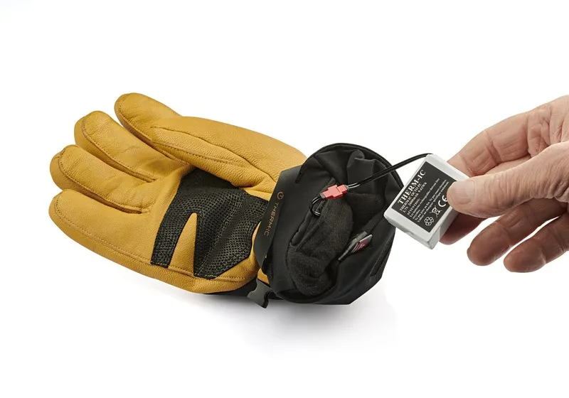 Gros plan : Therm-ic Gant avec batterie de rechange dans la main. Focus sur l'installation de la batterie.