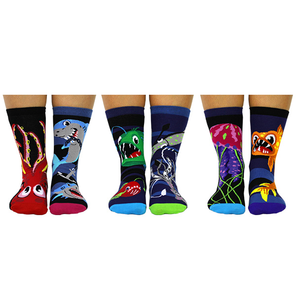 Sechs bunte `Socks of the Deep` Oddsocks mit Meeresmotiven an Füßen.