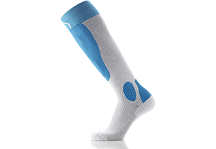 Grau-blaue Ski-Socke Grau-blaue Ski-Socke mit Gel-Schutz seitlich am Schienbein und Knöchel, schräg liegend, Profilansicht.