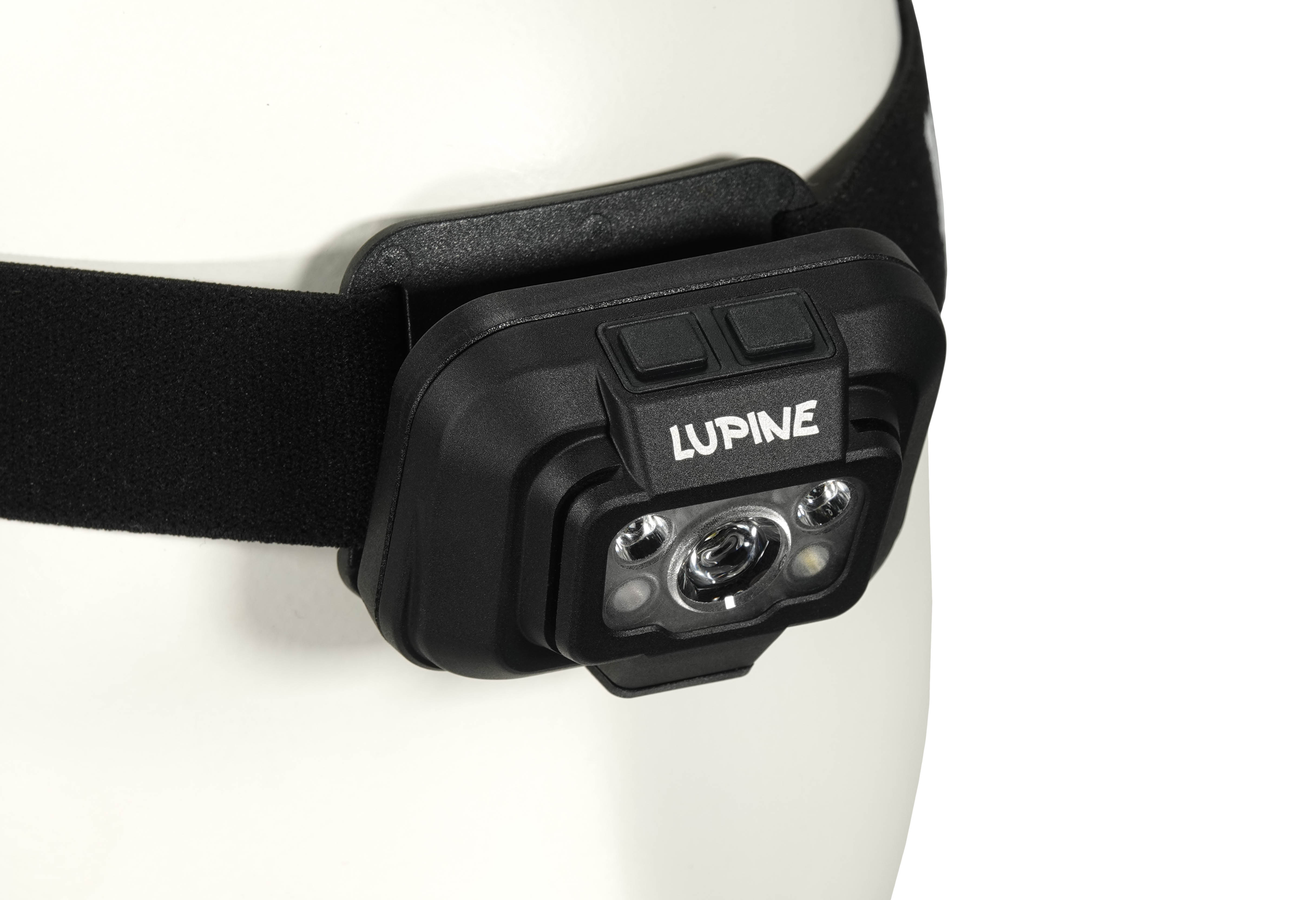Nahaufnahme einer Penta Stirnlampe mit schwarzem Stirnband an einem weißen Kopf. "Lupine" Schriftzug.