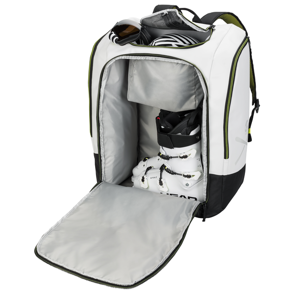 Geöffneter Head Rebels Racing Backpack 90L, gefüllt mit Skischuhen, Helm und Skibrille, Innenfächer sichtbar.