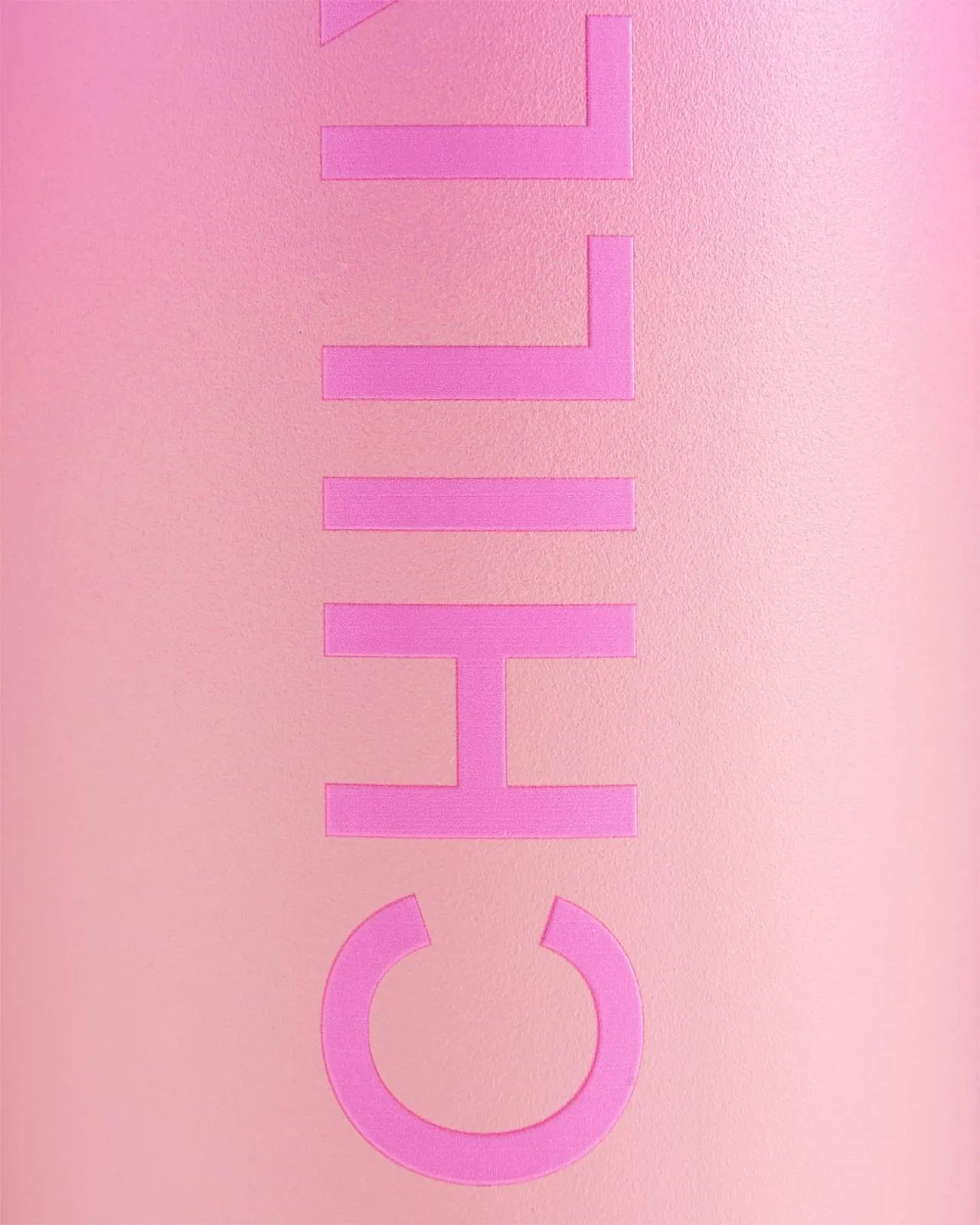 Primo piano di una bottiglia Chillys Series 2 Flip rosa con logo in rilievo su sfondo rosa ombreggiato.