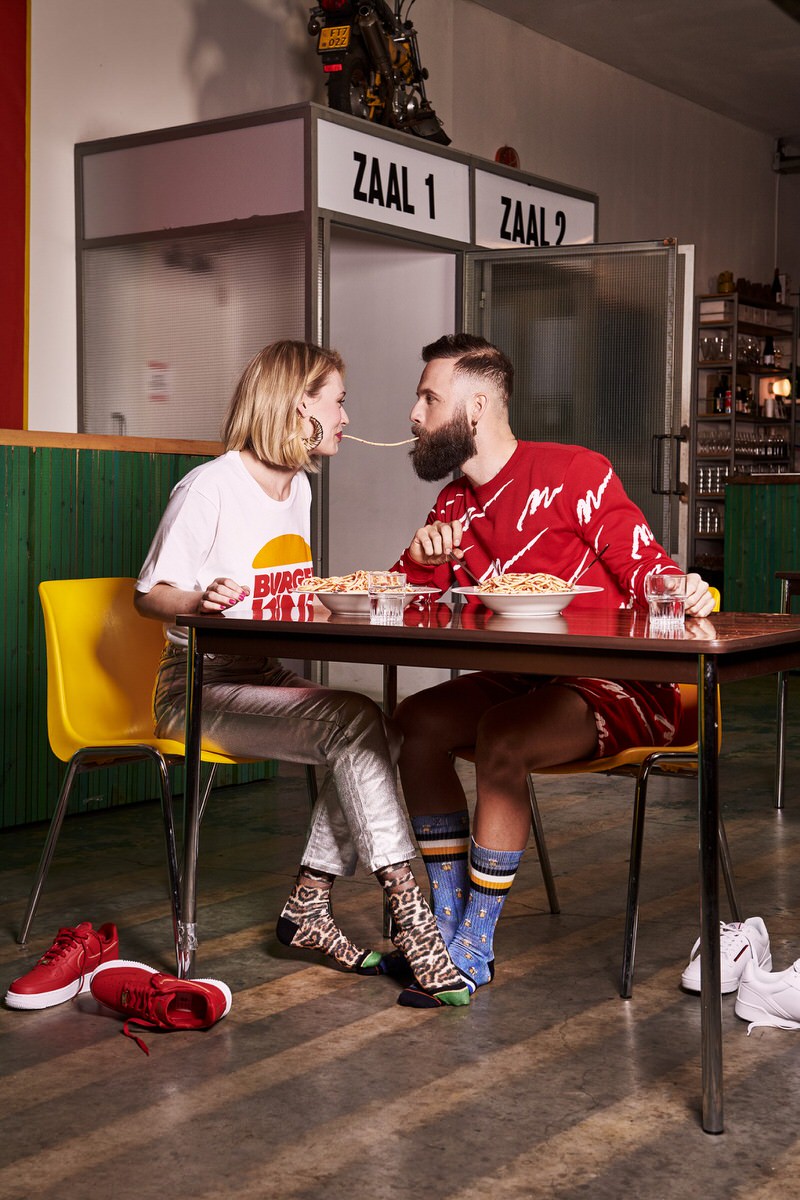 Ein Paar isst Spaghetti; er trägt XPOOOS Pint Luke Socken mit Bier-Motiv.