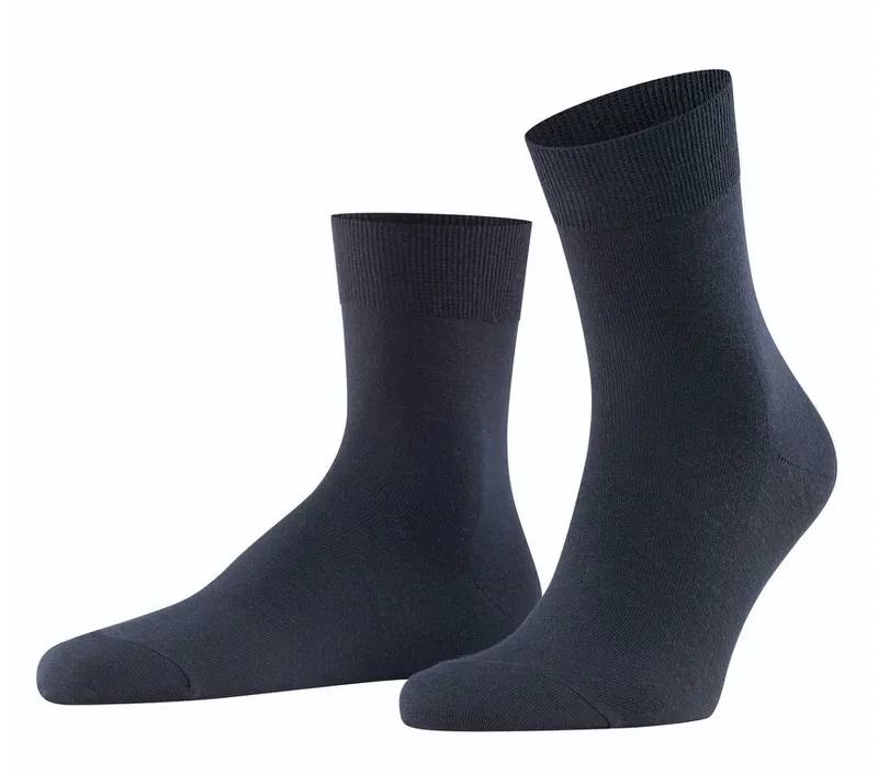 Two dark blue men's socks, one lying, one standing, against a white background.