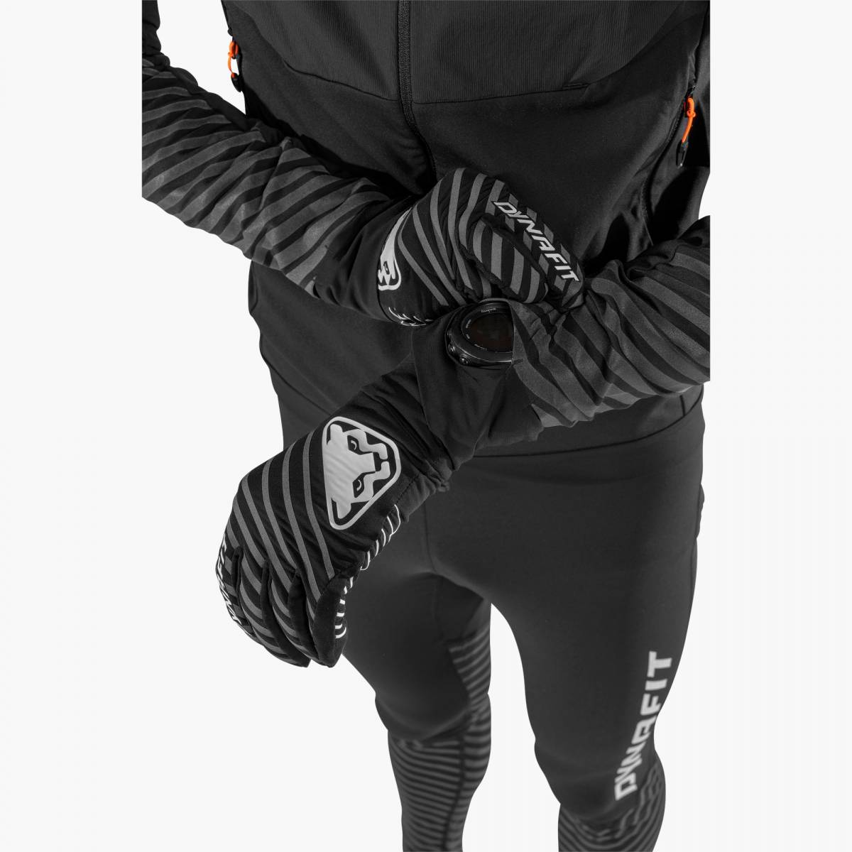 Gants réfléchissants Dynafit  Une personne porte des gants réfléchissants Dynafit Alpine avec des bandes et regarde une montre au poignet.